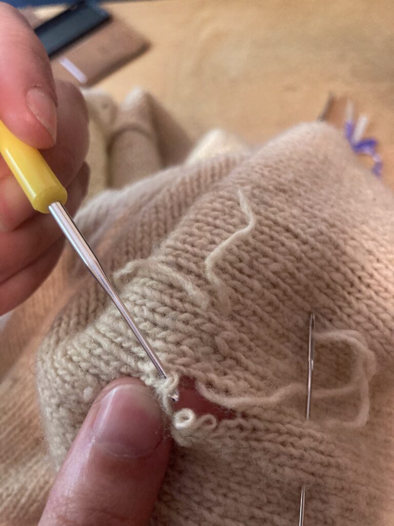 Remaillage en cours sur un pull
